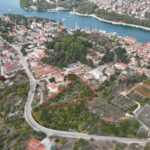 High-altitude drone image of investment land Hvar outlined in red showing closeness to Stari Grad harbour.