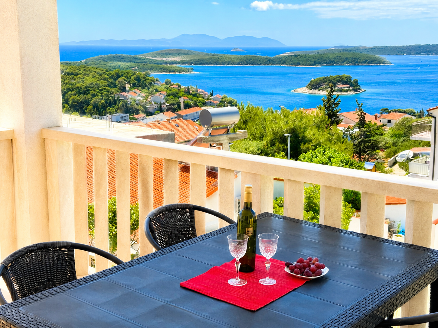 Covered terrace with dining table and sea views from a Hvar apartment.